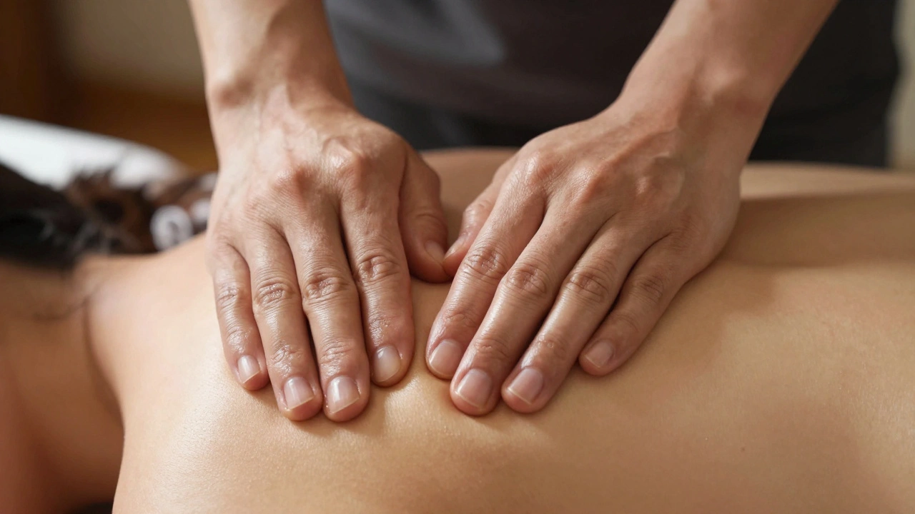 Therapist's hands gently working on a client's shoulder with warm, focused lighting.
