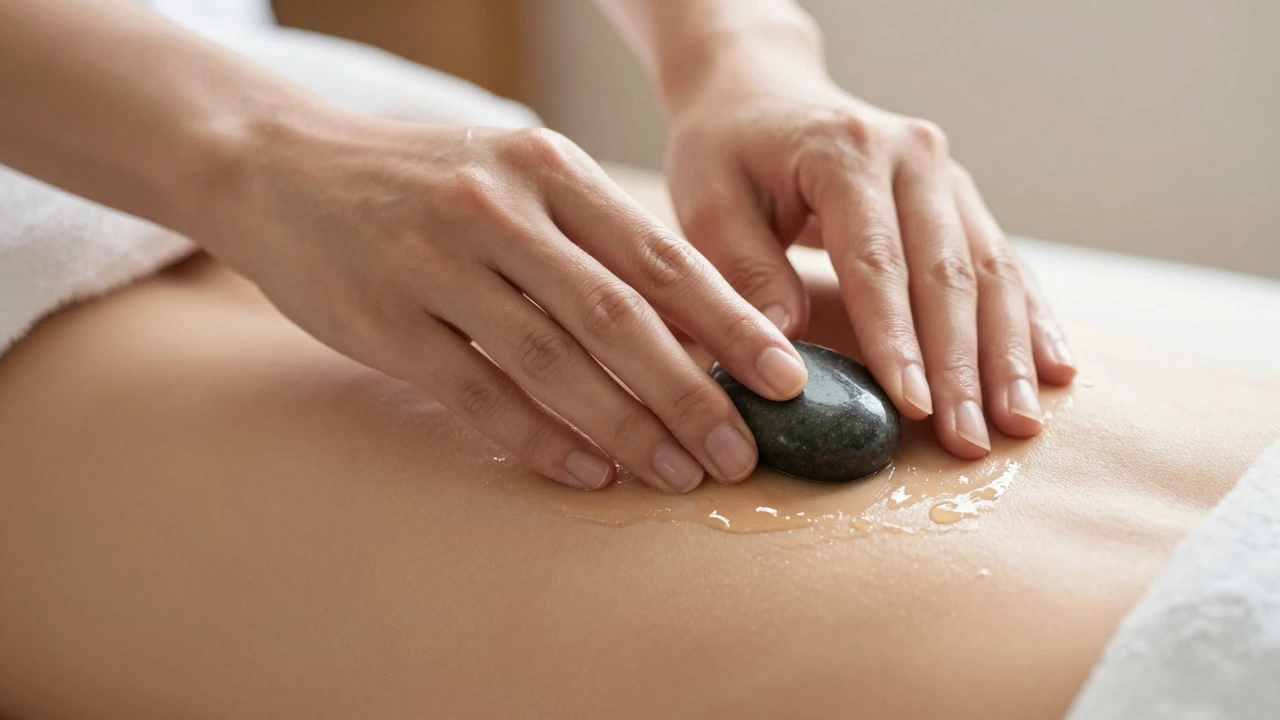 A therapist's hands gliding a warm stone over oiled skin in a gentle motion.